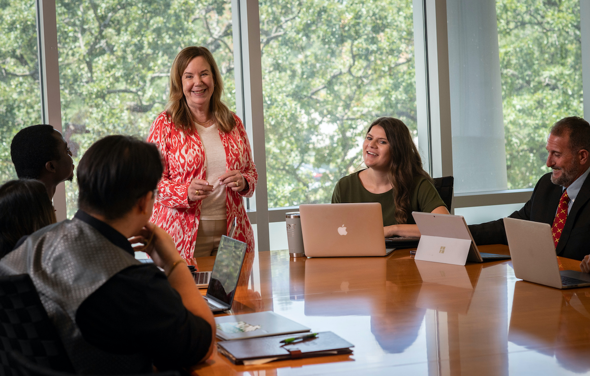 A professor leads a class in a conference room